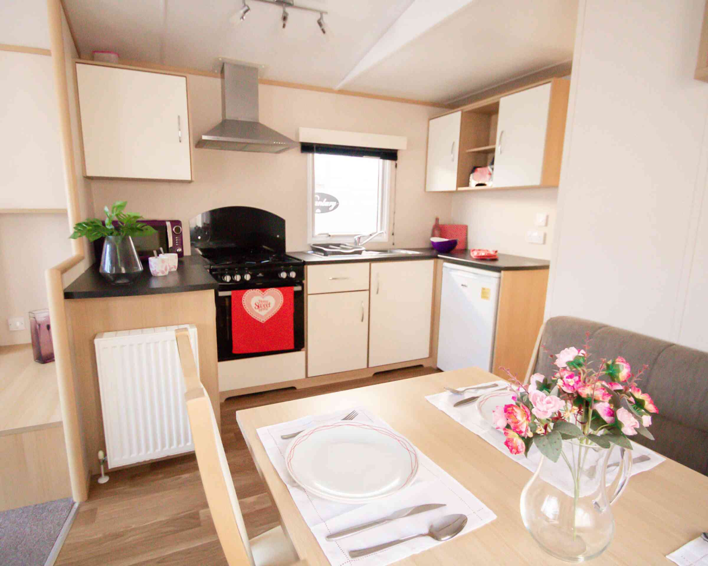 A well-equipped kitchen with a dining table, chairs, and a stove, highlighting a functional cooking space.