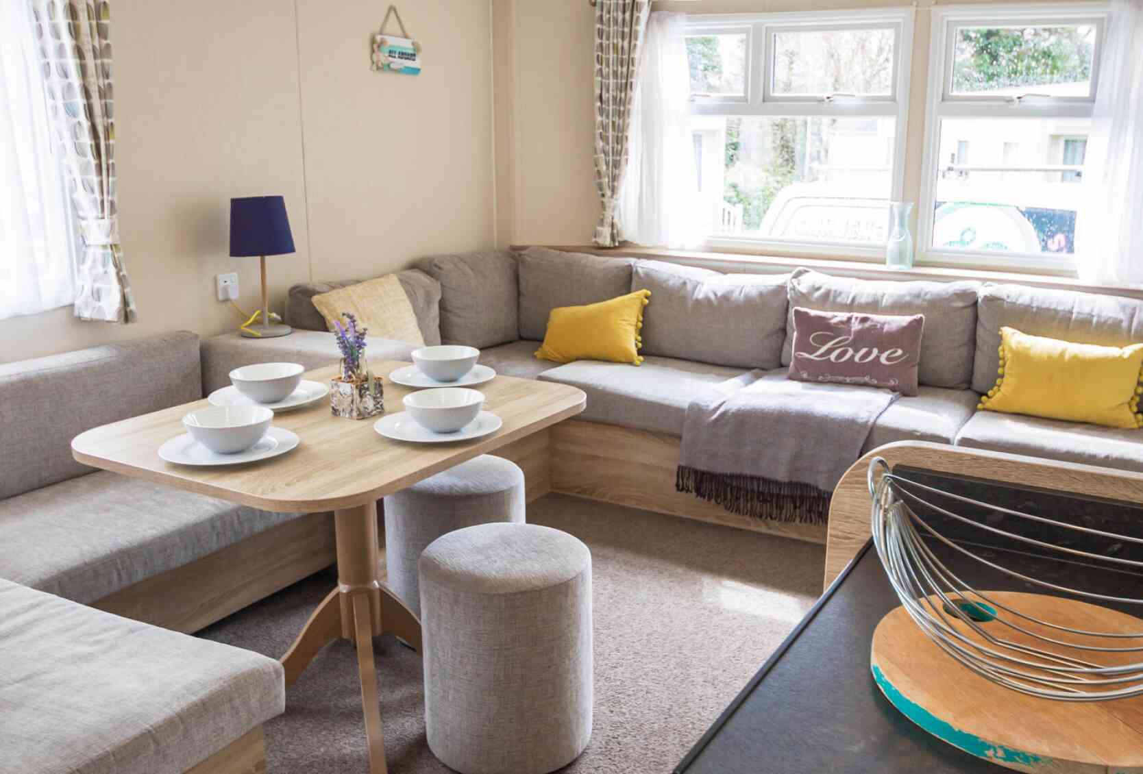 A stylish living room showcasing couches, various tables, and a coffee table, designed for comfort and conversation.