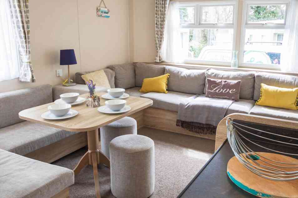 A stylish living room showcasing couches, various tables, and a coffee table, designed for comfort and conversation.