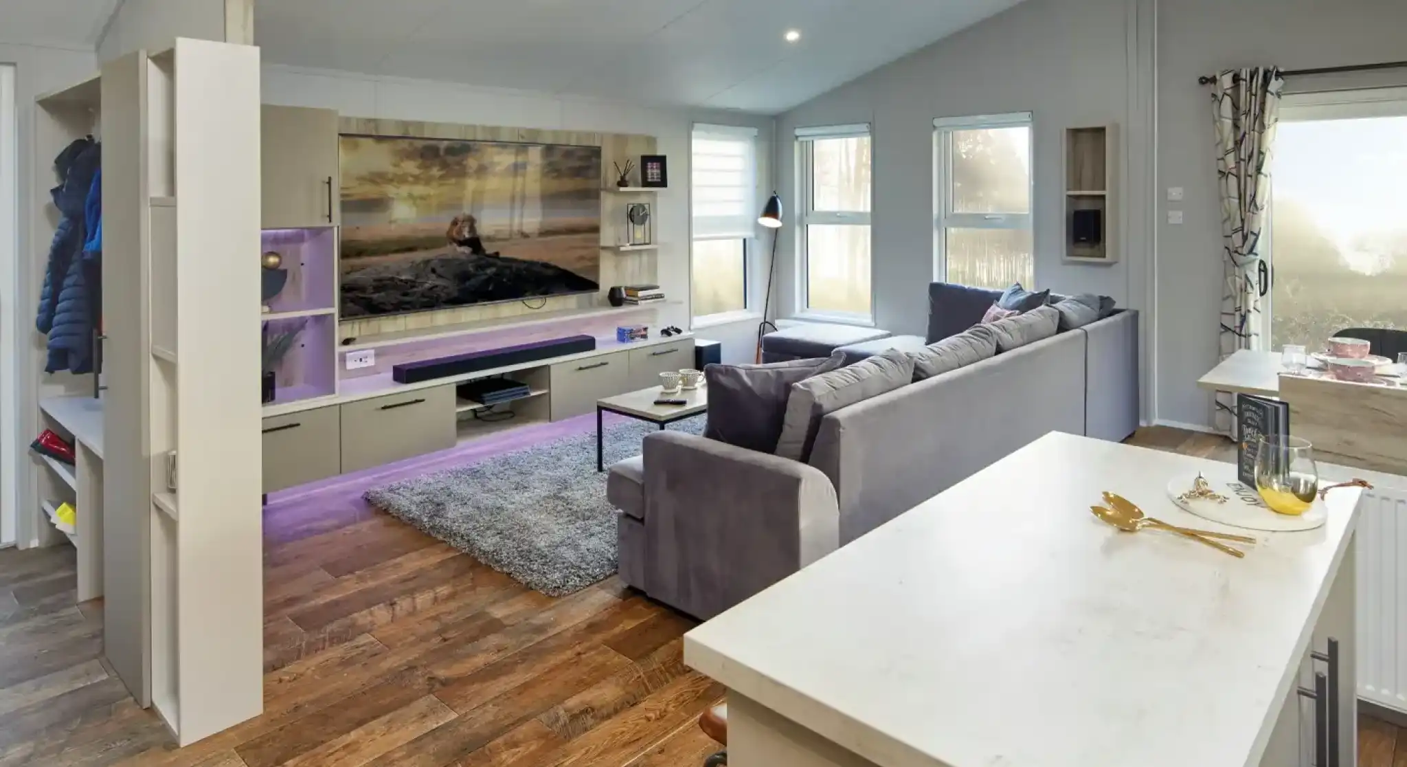 Modern living room with large sectional sofa, entertainment centre, and island breakfast bar.