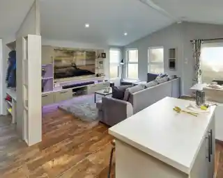 Modern living room with large sectional sofa, entertainment centre, and island breakfast bar.