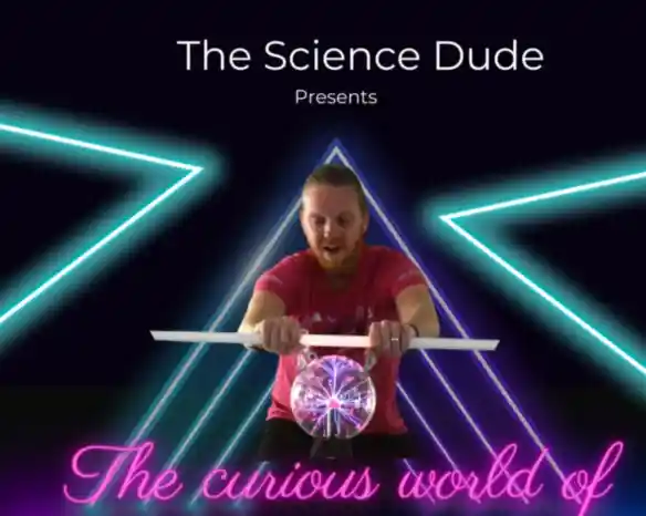 A man in a pink shirt is demonstrating a science experiment involving a clear sphere, surrounded by neon triangular shapes and bright lighting. The text above reads "The Science Dude Presents" and below, "The curious world of."