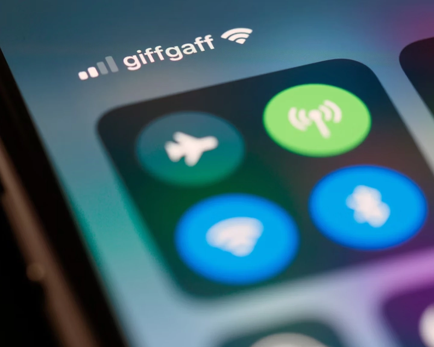 Close-up of a smartphone screen showing the control center with WiFi, Bluetooth, and airplane mode icons, and 'giffgaff' displayed as the mobile network provider with a WiFi connection icon.